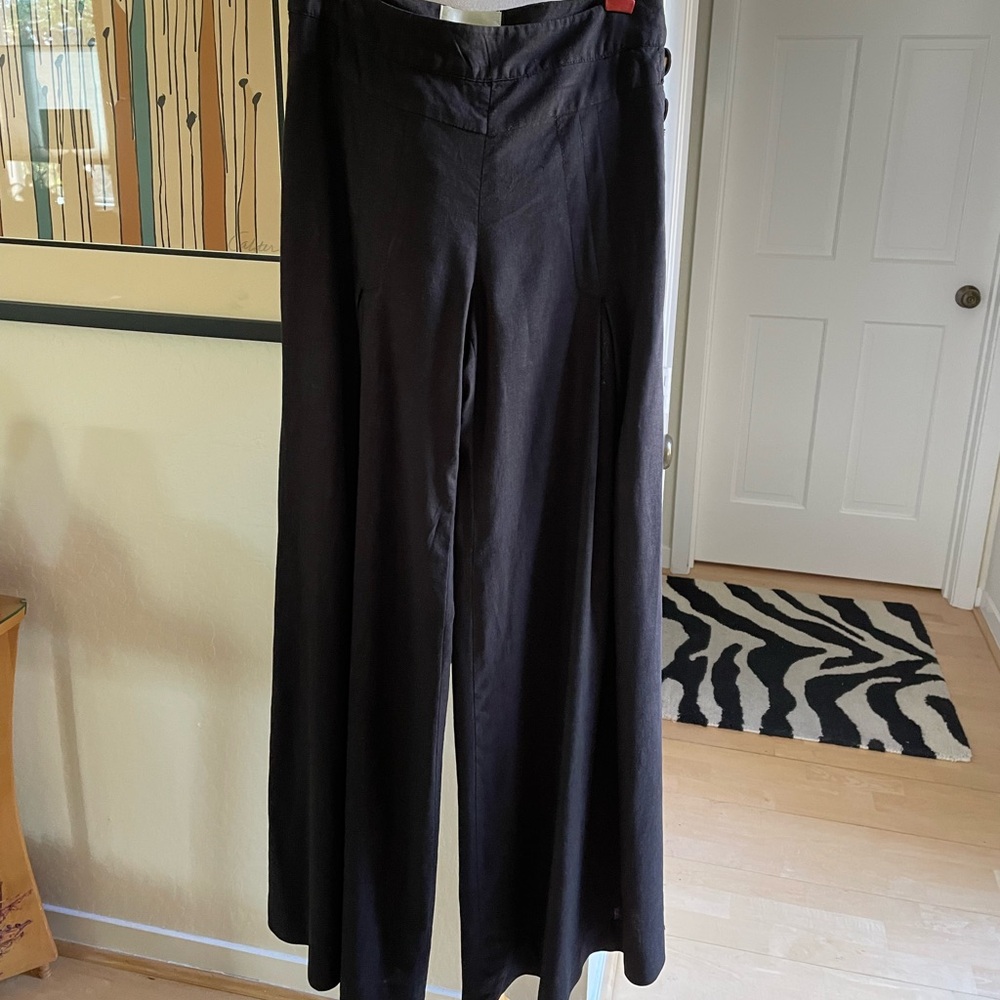 Anthropologie lovely black linen pants flared at bottom, with button details.